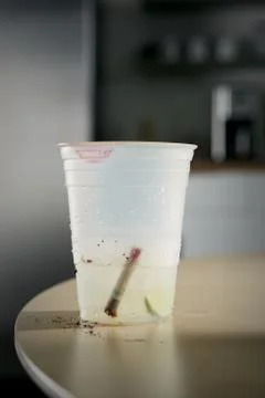 Extinguished cigarette in plastic glass Foto stock