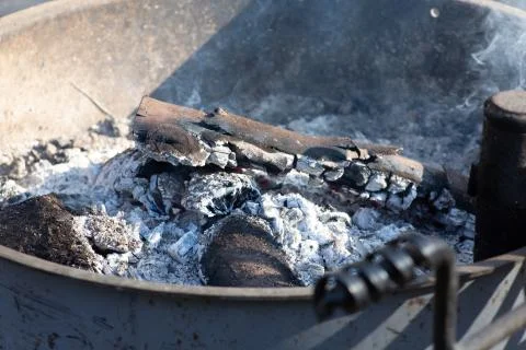 An extinguished fire inside a metal fire ring at the campground Foto stock