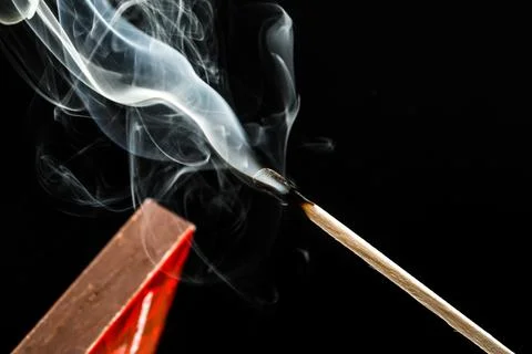 Extinguished match with smoke on blak background Stock Photos