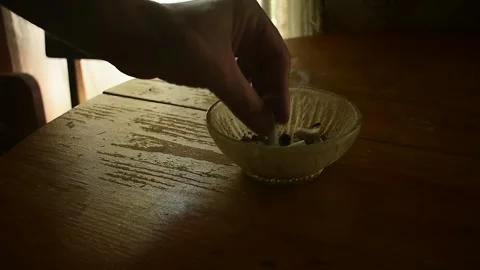 Extinguishes a cigarette butt in an ashtray Stock Footage 135412693