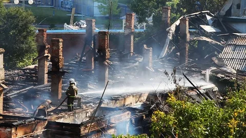 Extinguishing a fire in an old house by using water from a fire hose Stock-Footage 80020124