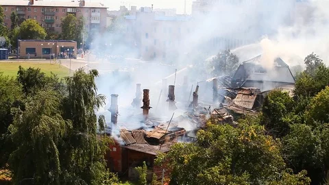 Extinguishing a fire in an old house by using water from a fire hose Stock Footage 80257595