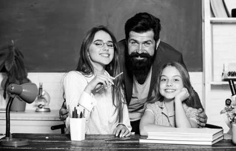 Extra classes. Gifted child. Little girl studying with team of tutors. Private Stock Photos