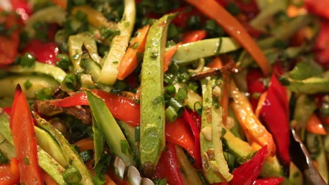 Extra close-up of Asian vegetable salad in a serving tray with set tongs. Media Video stock 150931969