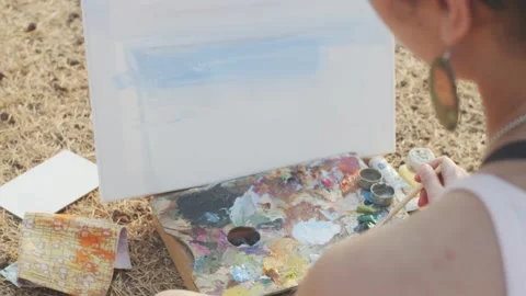 Extra close up back view of woman painting on white canvas outdoors slow motion Stock Footage 132475022
