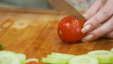 Extra Close up of Cutting one red cherry tomatoes with kitchen knife on wooden Stock Footage 78490228