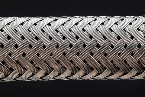 Extra Close-up of a metal hose isolated on black background. Stock Photos