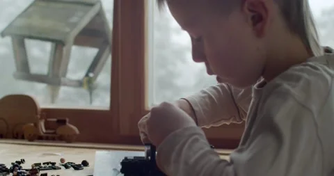 Extra close up side view of boy constructing toys from bricks slow motion. Macro Stock Footage 146825599