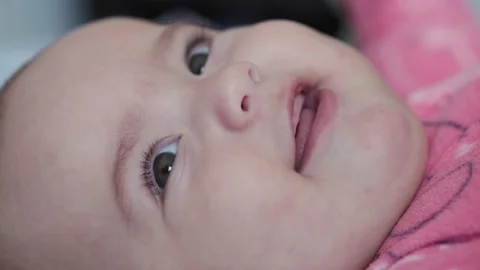 Extra close-up side view of chubby newborn calm awake baby in pink bodysuite Stock Footage 143794539