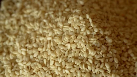 Extra close up video with rotation movement of raw sesame grains on a wooden Video stock 244487257