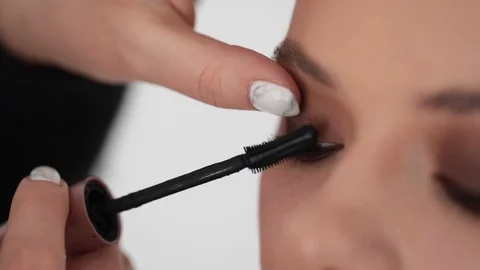 Extra close up view of master make-up artist applying mascara on female face Stock Footage 93760973