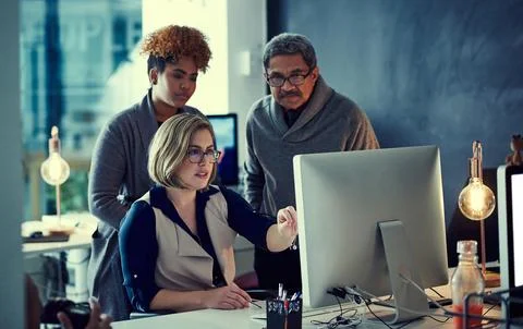 The extra effort makes all the difference. a group of businesspeople working Stock Photos