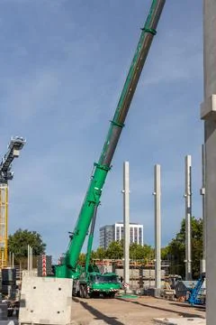 Extra heavy weight load mobile boom crane working modern city construction site Stock Photos