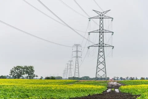 Extra-high voltage 400 kV overhead power line on large pylons, green field. Stock Photos