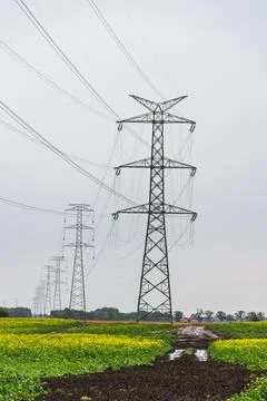 Extra-high voltage 400 kV overhead power line on large pylons, green field. Stock Photos