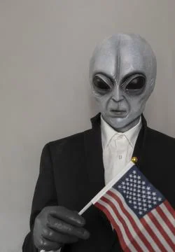 Extra Terrestrial Being, Portrait Of Alien Wearing Suit And Holding American Usa Stock Photos