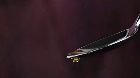 Extra virgin olive oil over a spoon with drops isolated on wood background Stock Footage 51913133