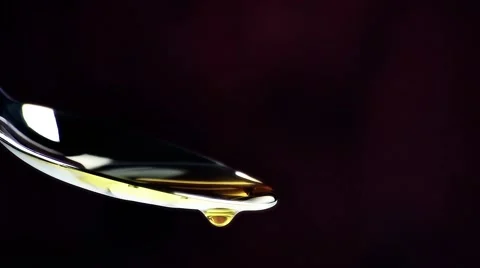 Extra virgin olive oil over a spoon with drops on dark wood background Stock Footage 51934732