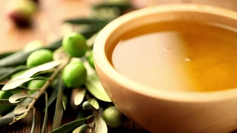 Extra Virgin Olive Oil Pouring into Wooden Bowl Stock Footage 335407645