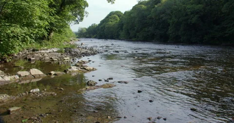 Extra wide shot looking up the river Lune next to the Devils bridge at Kirkby Stock Footage 328892740