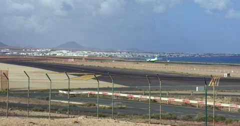 Extra wide shot looking through the fence to the runway with Aeroplane landing Vídeo Stock 336721660