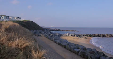 Extra wide shot of rock Groynes, sea wall and marram grass, at Hopton holiday Stock Footage 341602007