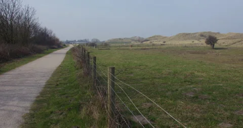 Extra Wide zoom shot of the sand dunes and animal pasture land on Talacre Stock Footage 346109892