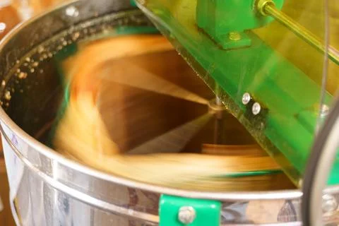 Extraction of honey from honeycombs of nesting frames in a honey extractor. Stock Photos
