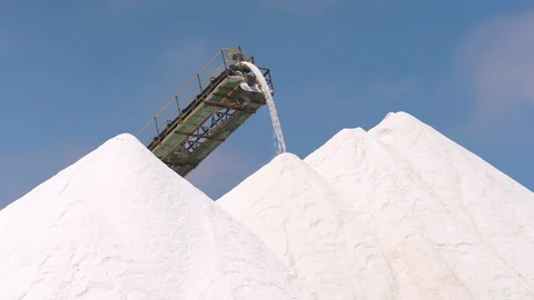 Extraction of salt from a pan, clouds coloured by pink water, wide shot. Salt In Stock Footage 100788626