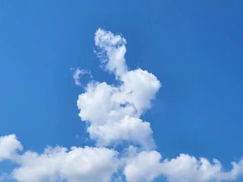 An extraordinary white fluffy cloud resembling a rabbit with an ear 写真素材