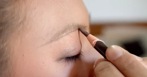 Extream close up, hand holding a pencil to draw a new eyebrow shape. Stock Footage 222739851