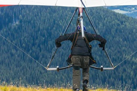 Extremal man with hang-glider preparing to fly Back view of professional H... Stock Photos