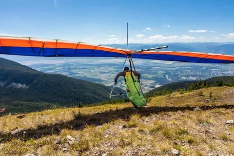 Extremal man with hang-glider preparing to fly Hang glider pilot running a... Stock Photos