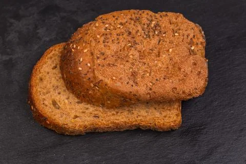 Extreme and average cereal brown bread slices on slate plate Stock Photos