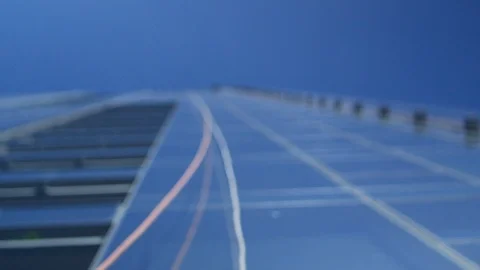 Extreme angle of safety ropes for window washers dangling from glass skyscraper Stockbeeldmateriaal 124784355