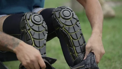 Extreme athlete pulling pants over his knee pads Stock Footage 81494541