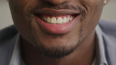 Extreme close up of an african american young adult man smiling Stock Footage