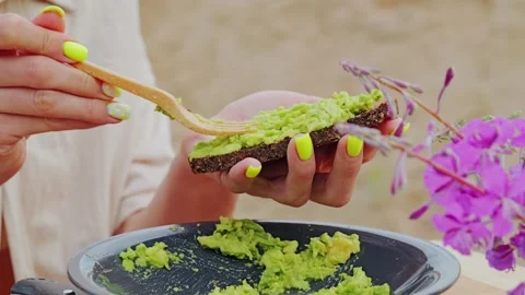 Extreme Close Up of Avocado Spread on Rye Bread With Eco Wooden Spoon Stock Footage 336325962