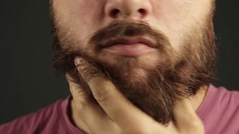 Extreme close up of beard man having an itch. Arranging the beard Stock Footage 93079152