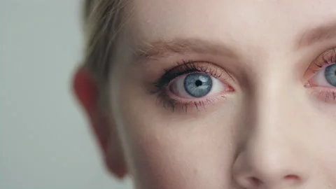 Extreme close beautiful blonde model's eyes opening to camera pan to both eyes Stock Footage 193973957