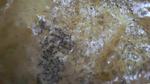 Extreme close up of boiling tea with bubbles and spices texture Stock Footage 324348802