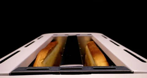 Extreme close up of bread cooking in a toaster with toast flying in slow motion Stock Footage 260075694