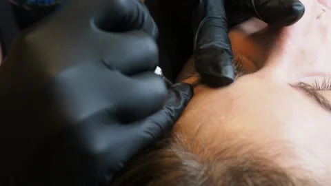 Extreme close-up of brow stroke during microblading with gloved hands in full Stock Footage 307494951