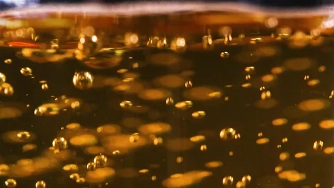 Extreme Close Up of Bubbles Rising in Golden Sparkling Liquid Stock Footage 325689813