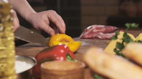 Extreme close up chef in restaurant kitchen cut yellow pepper with sharp, shiny Stock Footage 150635153