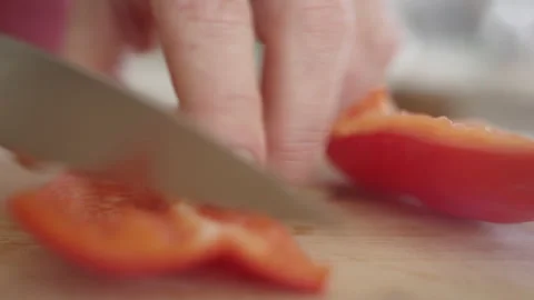 Extreme close up of chef slicing red bell pepper Stock Footage 151845182