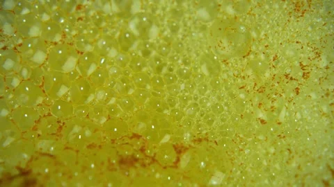Extreme close up of a citrus flavored effervescent tablet dissolving in water Stock Footage 331742040