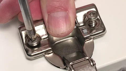 Extreme close-up of a concealed cabinet hinge being tightened with a screwdriver Stock Footage 335572824