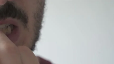 Extreme close up with copy space of young man biting his nails Stock Footage 161552455