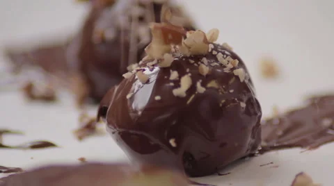 Extreme close up of crushed nuts being applied to chocolate mousse truffles Stock-Footage 60719926